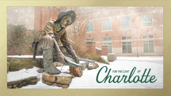 The miner statue covered in snow with the words "For the Love of Charlotte" over it.