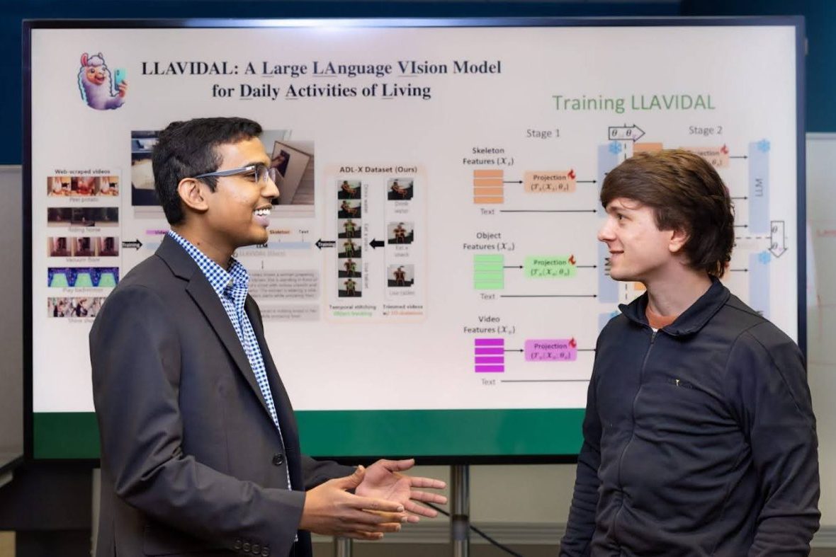 Two faculty members talking in front of white board